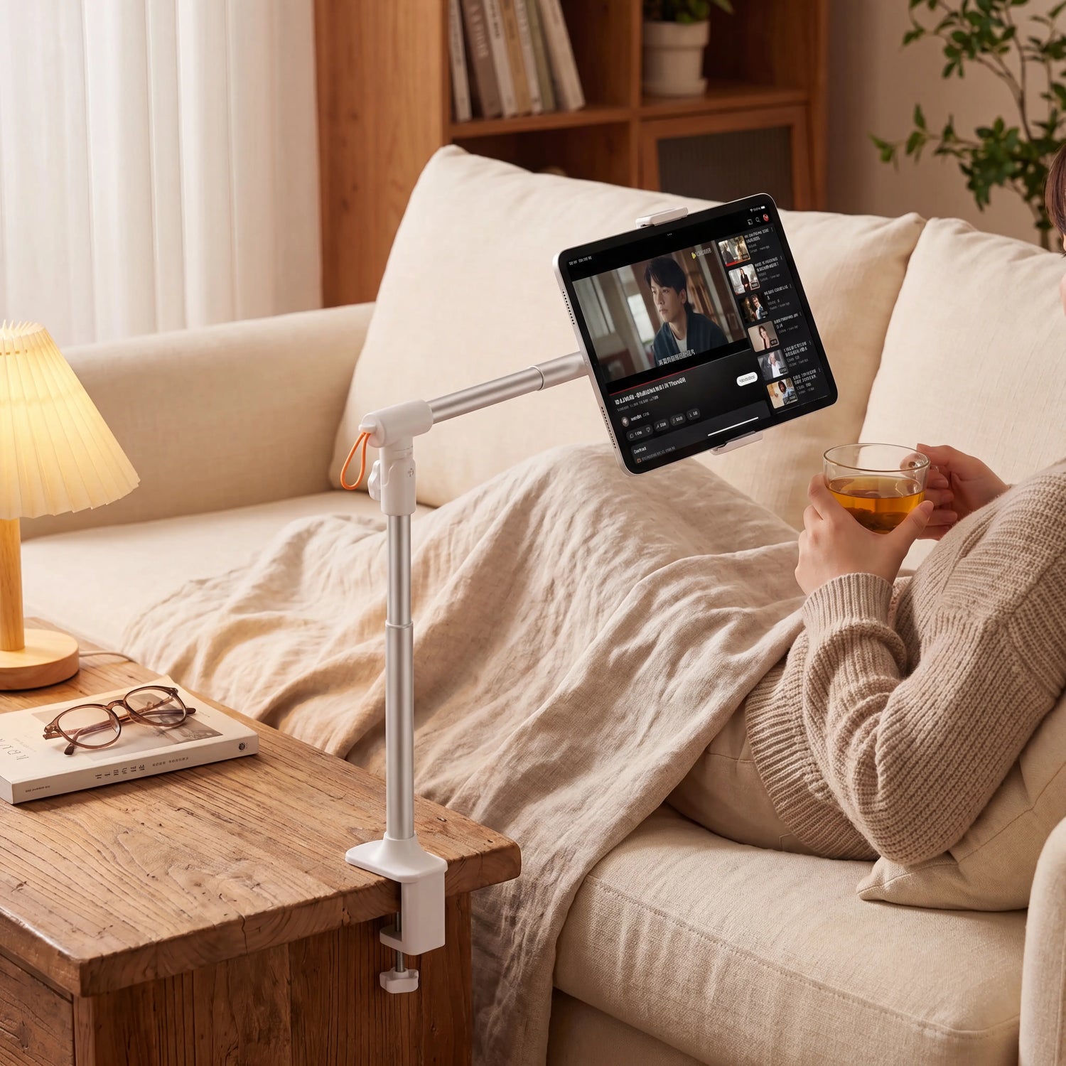 Adjustable gooseneck tablet and phone holder clamped to a bed frame